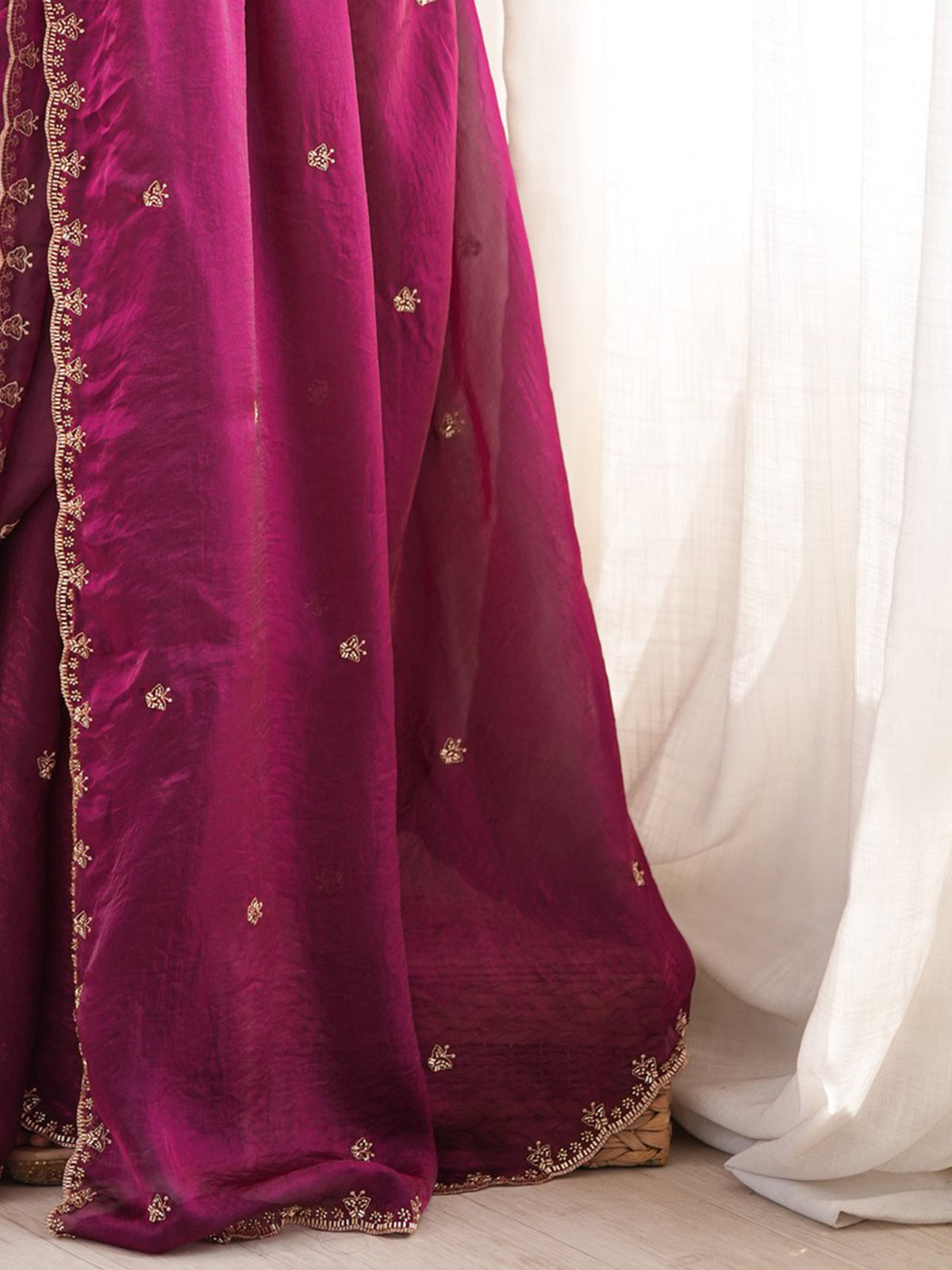 Pallu detail of wine satin saree showing ornamented surface design and embellished border