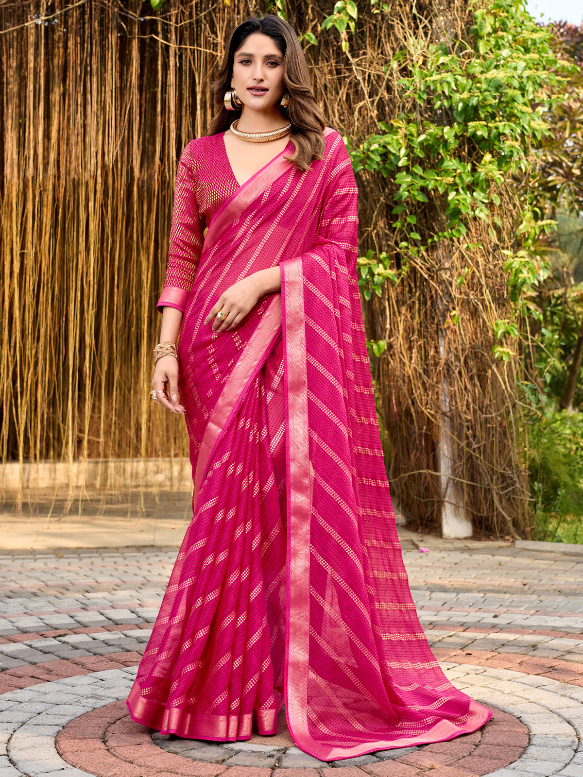 Woman wearing pink chiffon saree with metallic foil print work and pink blouse