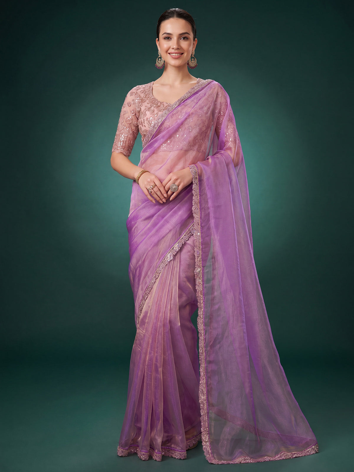 Woman wearing lavender georgette saree with ornamented surface design and rose gold blouse
