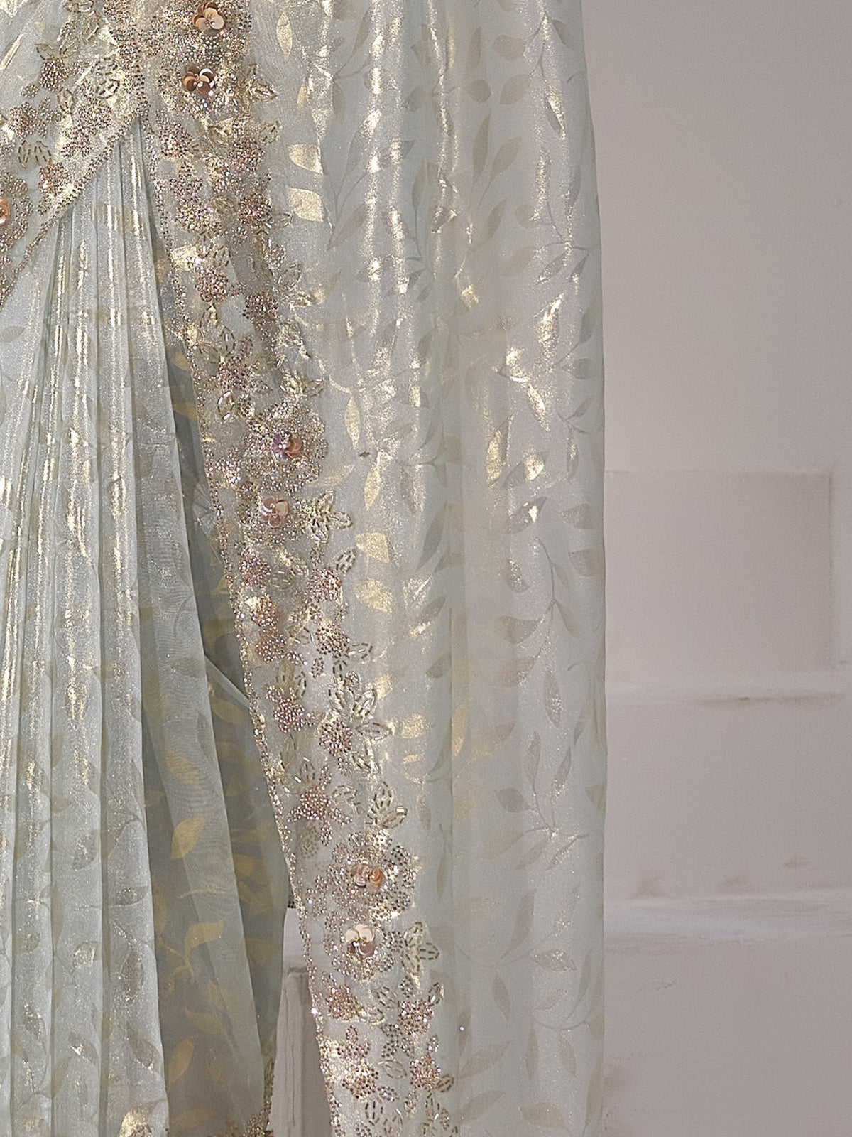 Pallu detail of light blue organza saree showing applique design and scallop border