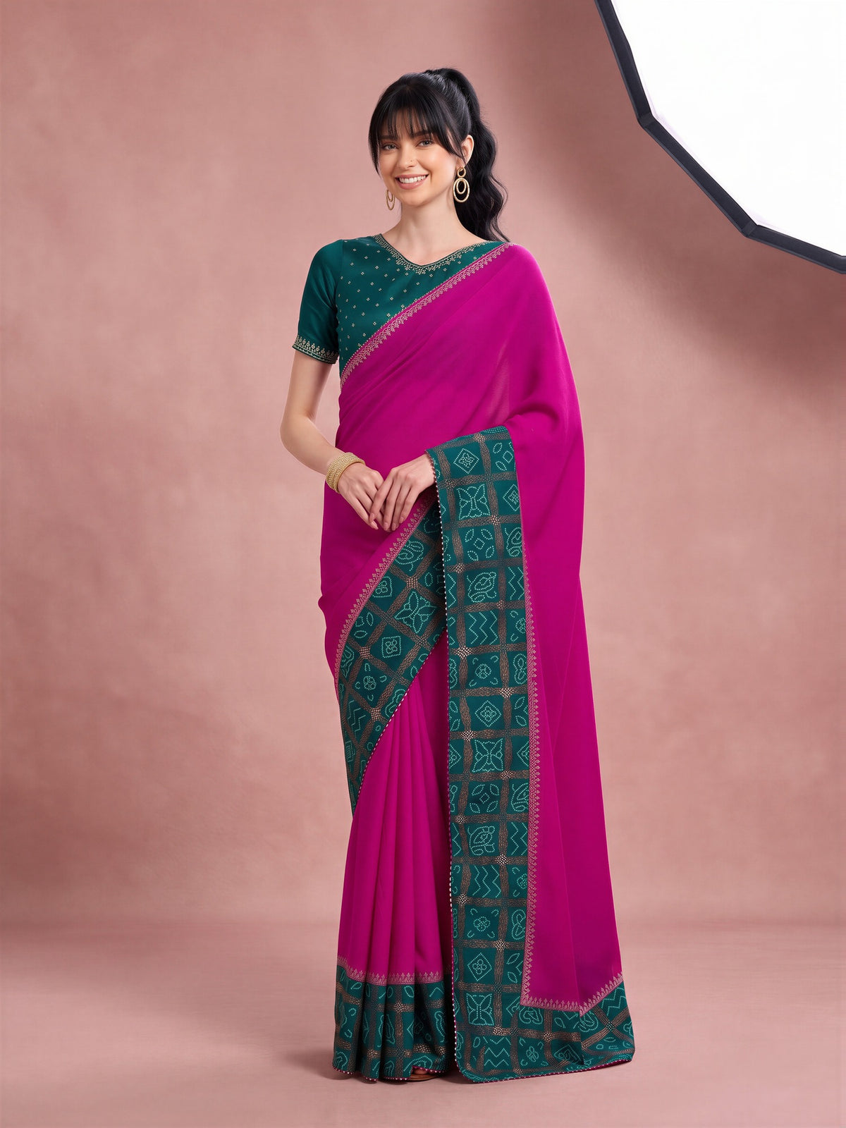 Woman wearing magenta vichitra silk saree with bandhani tie-dye dot work and teal blue blouse