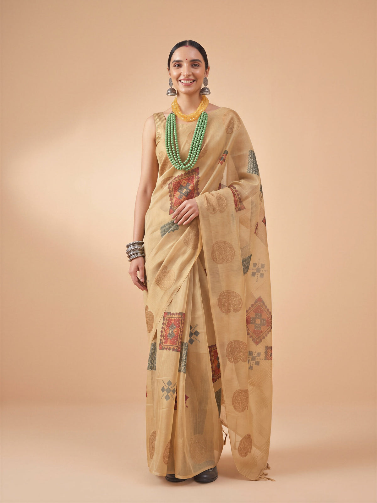 Woman wearing beige tissue saree with traditional indian motif work and beige blouse