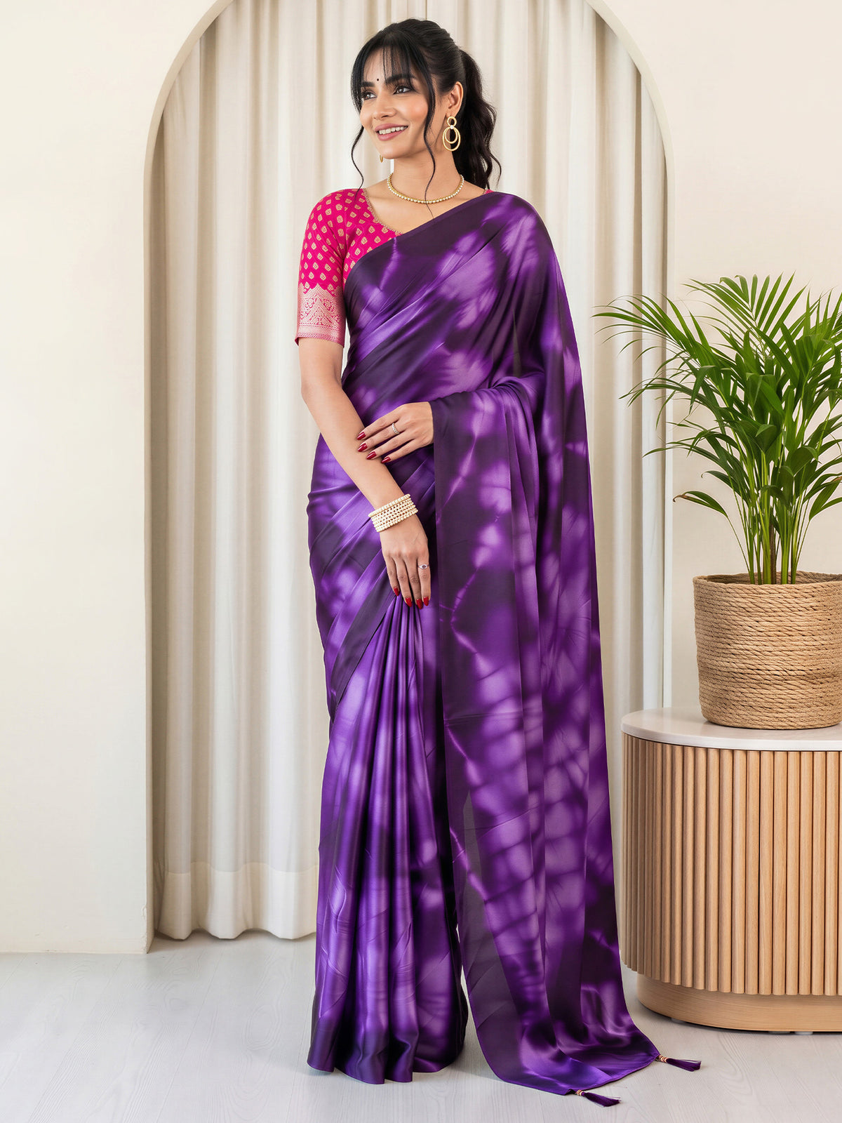 Woman wearing purple satin silk saree with tie-and-dye resist pattern and pink blouse