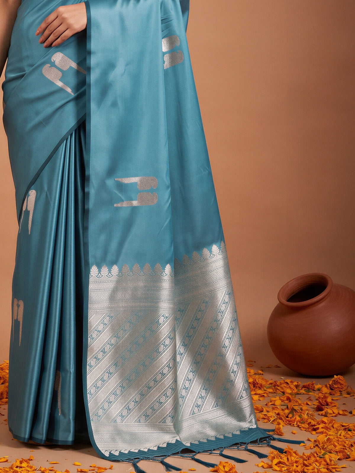 Pallu detail of light blue satin saree showing botanical floral and leaf design and zari border