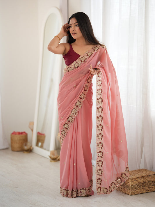 Woman wearing peach georgette saree with ornamented surface design and maroon blouse