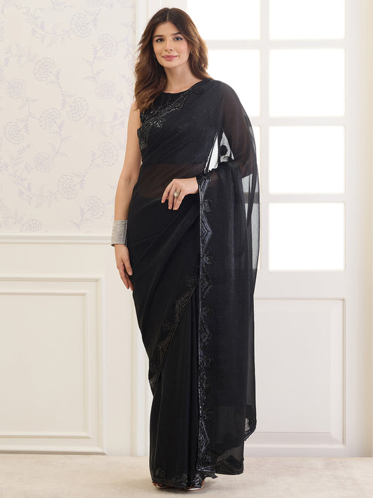 Woman wearing black pure chiffon saree with ornamented surface design and black blouse