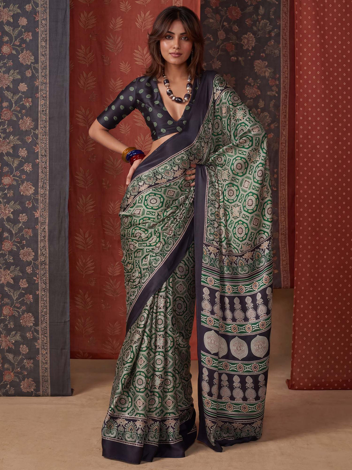 Woman wearing green crepe saree with ajrak block-print motif work and black blouse