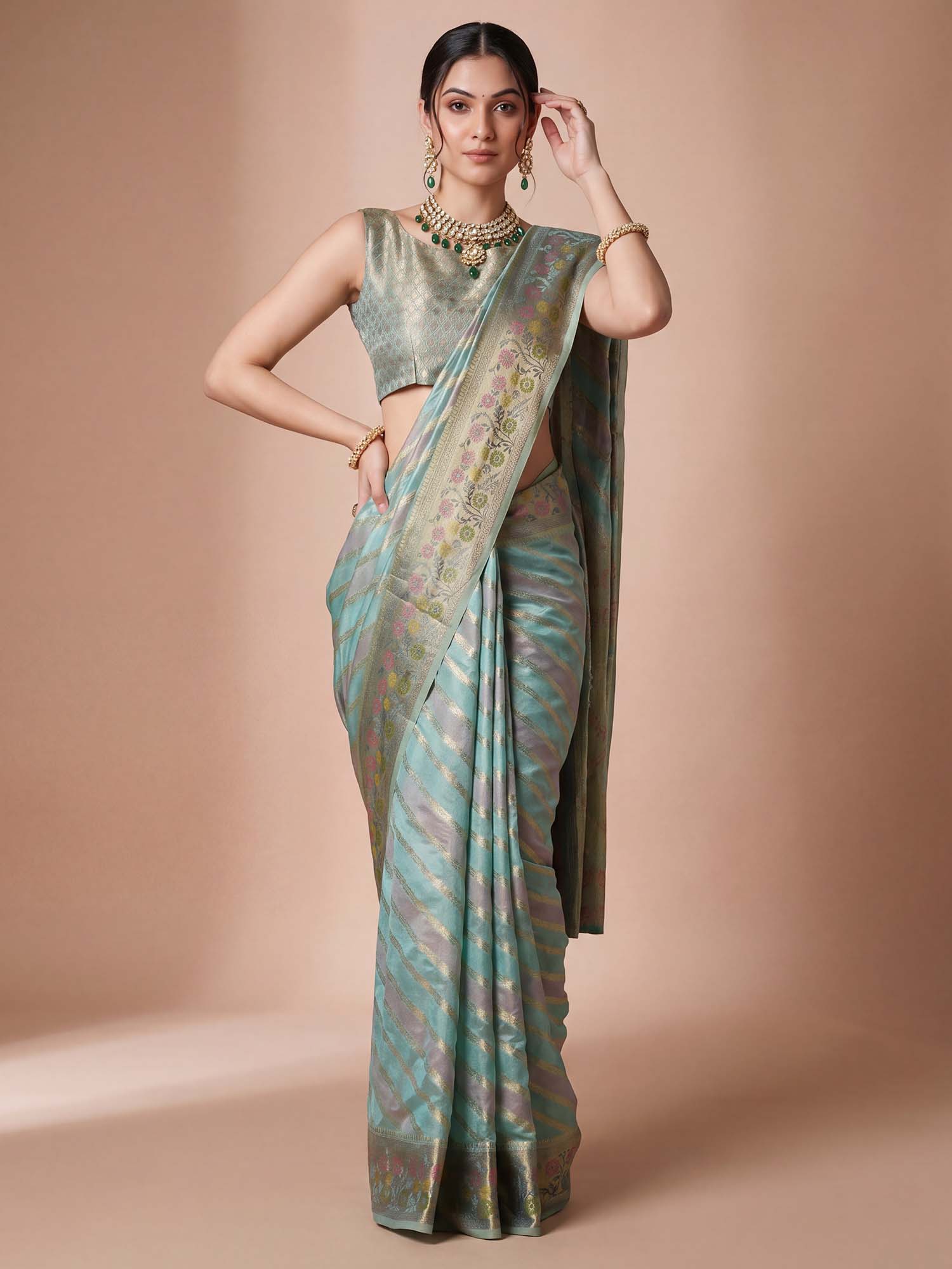 Woman wearing light blue organza saree with striped pattern design and light blue blouse
