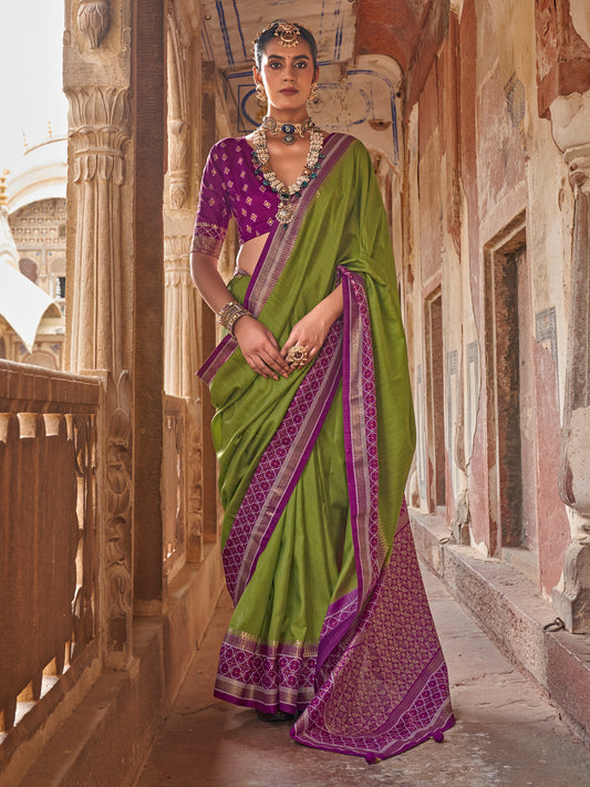 Woman wearing green silk blend saree with clean solid-tone finish and purple blouse