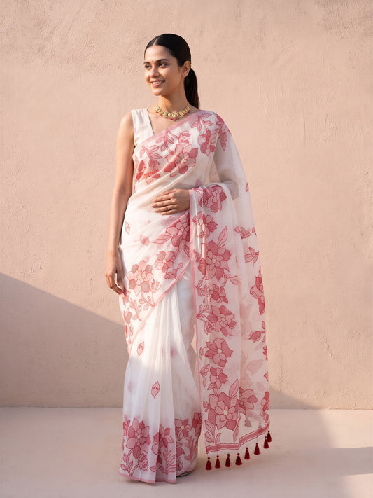 Woman wearing white cotton linen saree with traditional indian motif work and white blouse