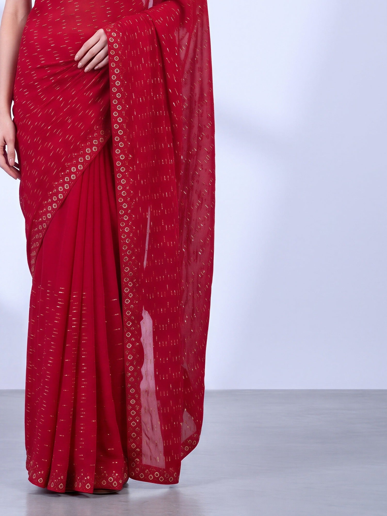 Pallu detail of red tissue saree showing geometric pattern design and embellished border