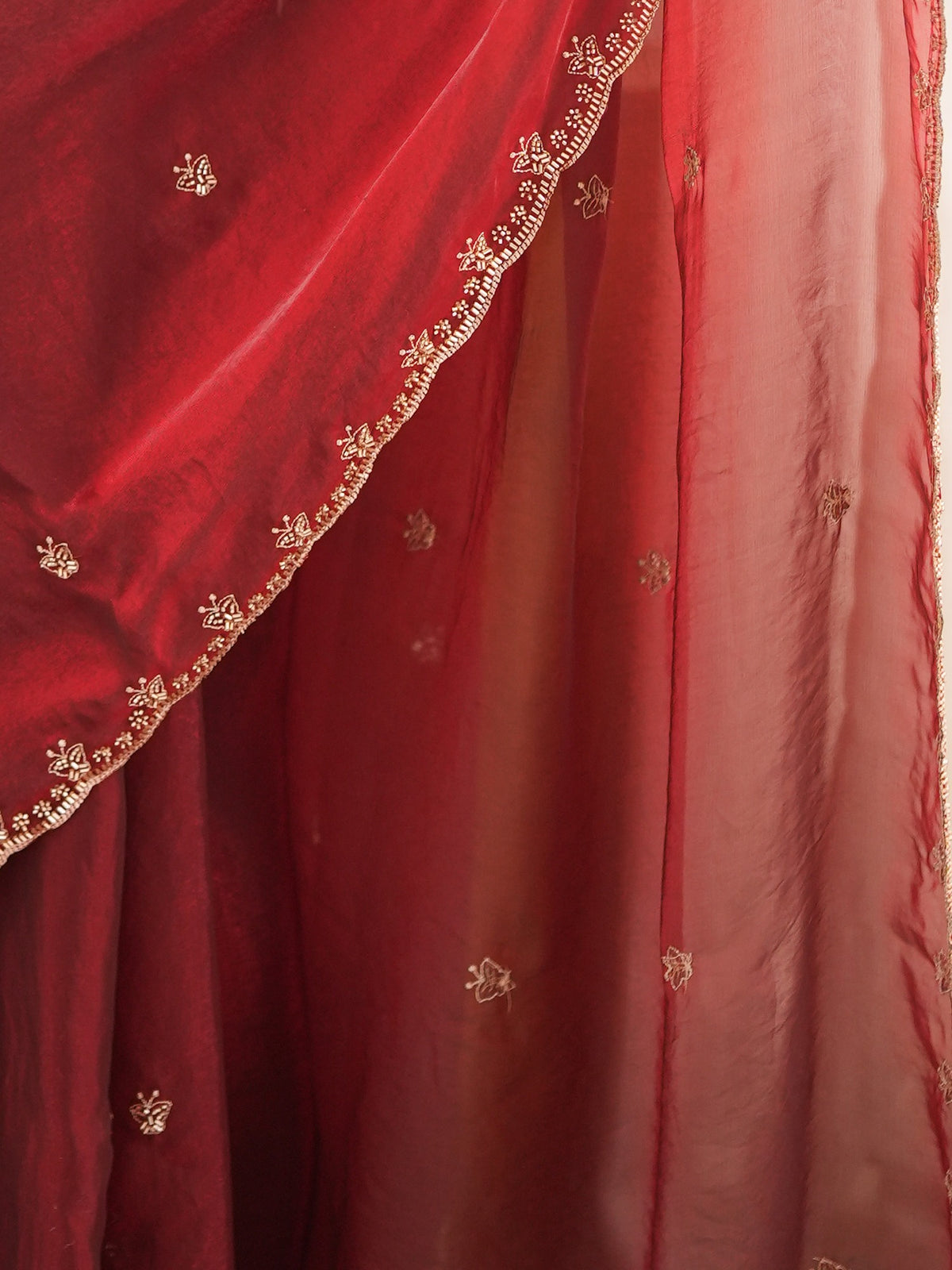 Pallu detail of maroon satin saree showing ornamented surface design and embellished border