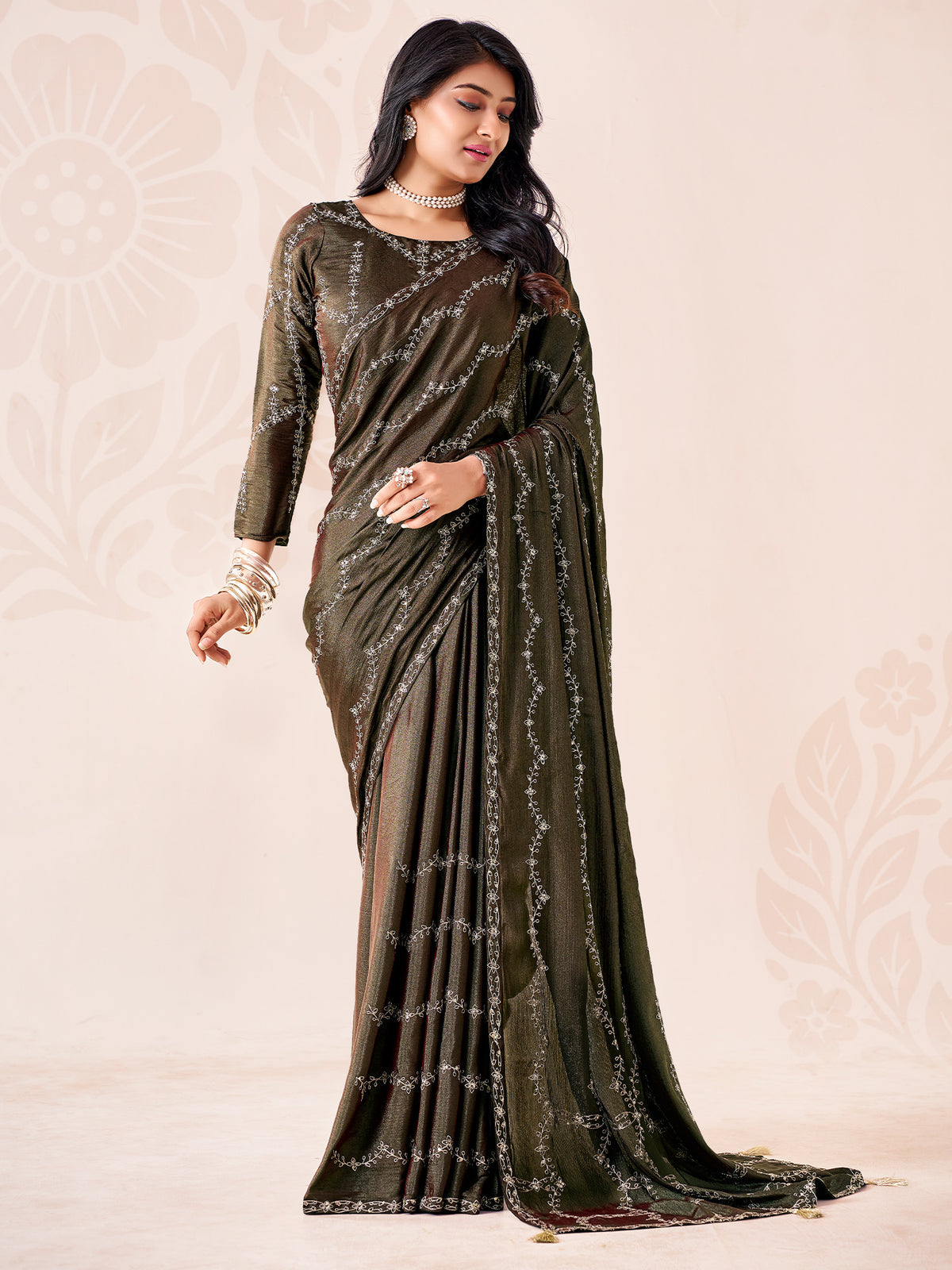 Woman wearing dark green chiffon saree with ornamented surface design and dark green blouse