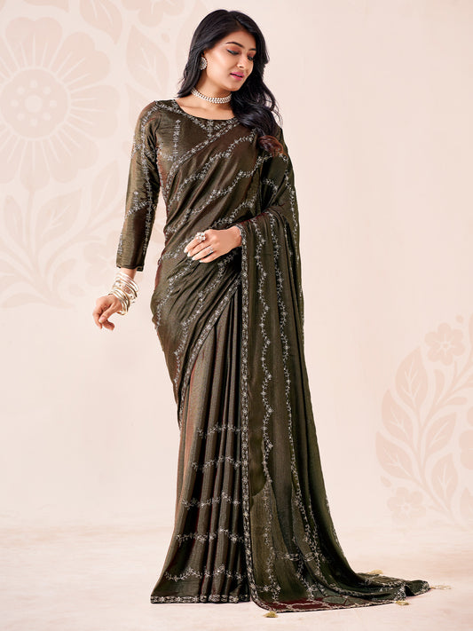 Woman wearing dark green chiffon saree with ornamented surface design and dark green blouse