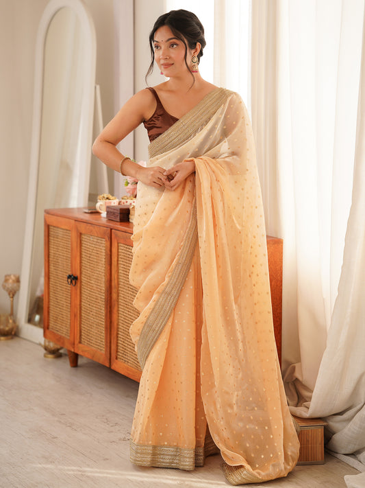 Woman wearing yellow silk blend saree with zari butta (metallic motif) work and brown blouse