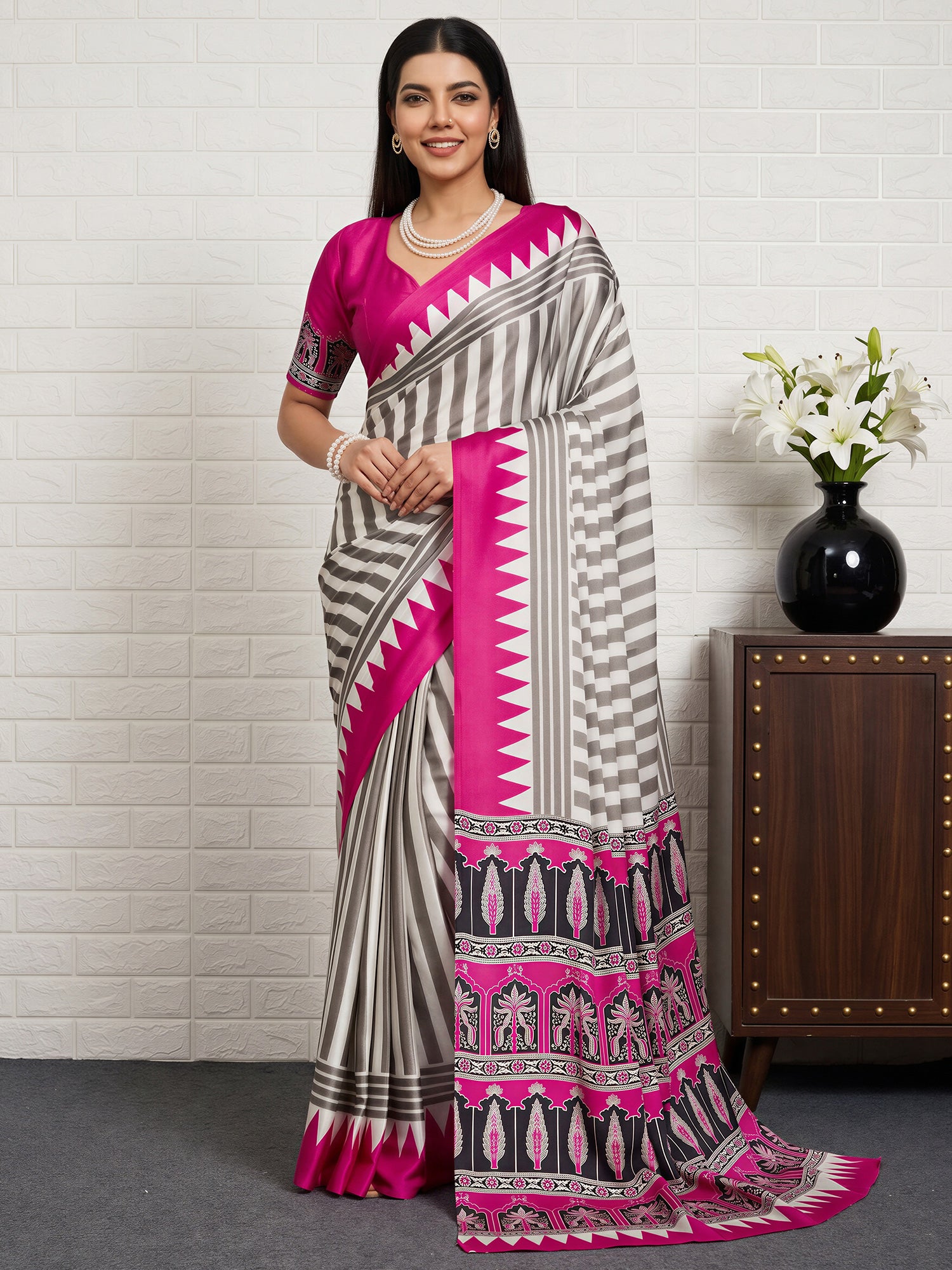 Woman wearing pink satin saree with striped pattern design and pink blouse
