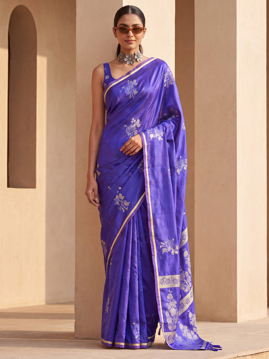 Woman wearing purple satin silk saree with all-over floral design and purple blouse