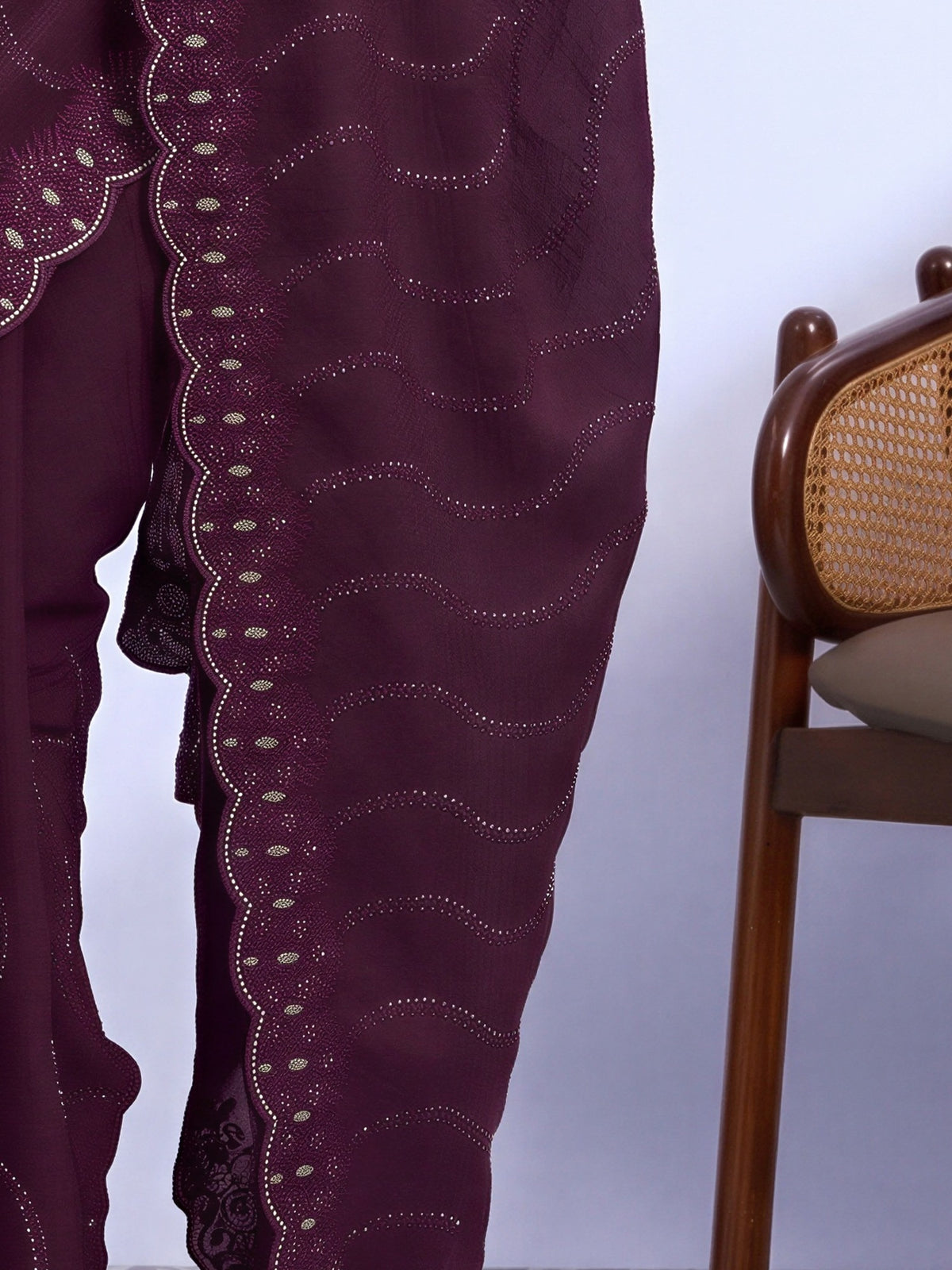 Pallu detail of wine tissue saree showing geometric pattern design and embellished border