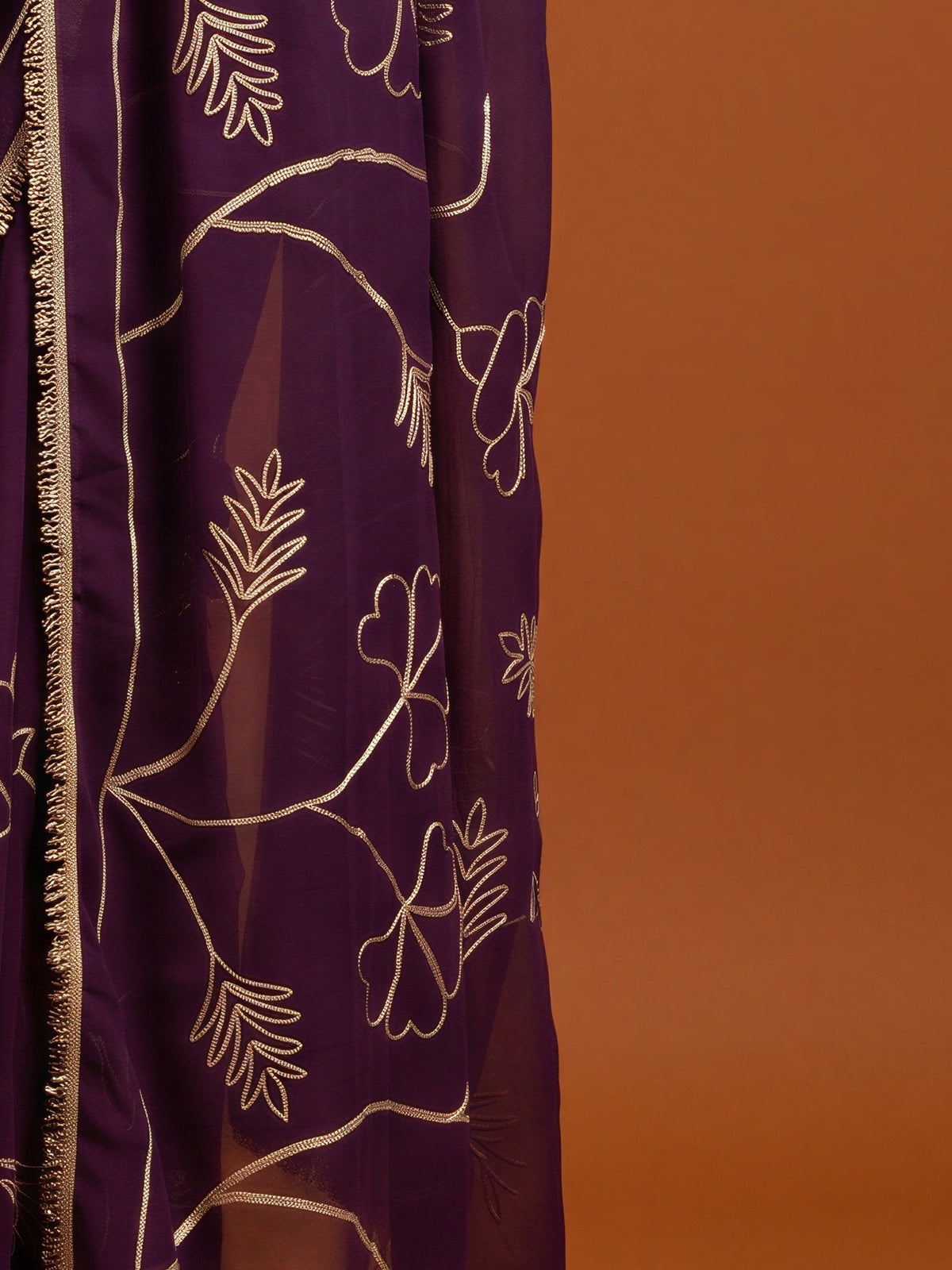 Pallu detail of purple georgette saree showing embroidered motif work and embellished border