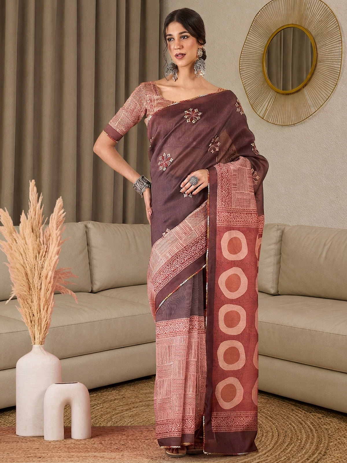 Woman wearing light brown silk blend saree with all-over floral design and peach blouse