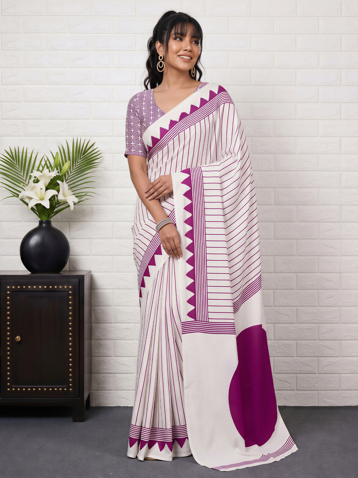 Woman wearing white satin saree with striped pattern design and white blouse