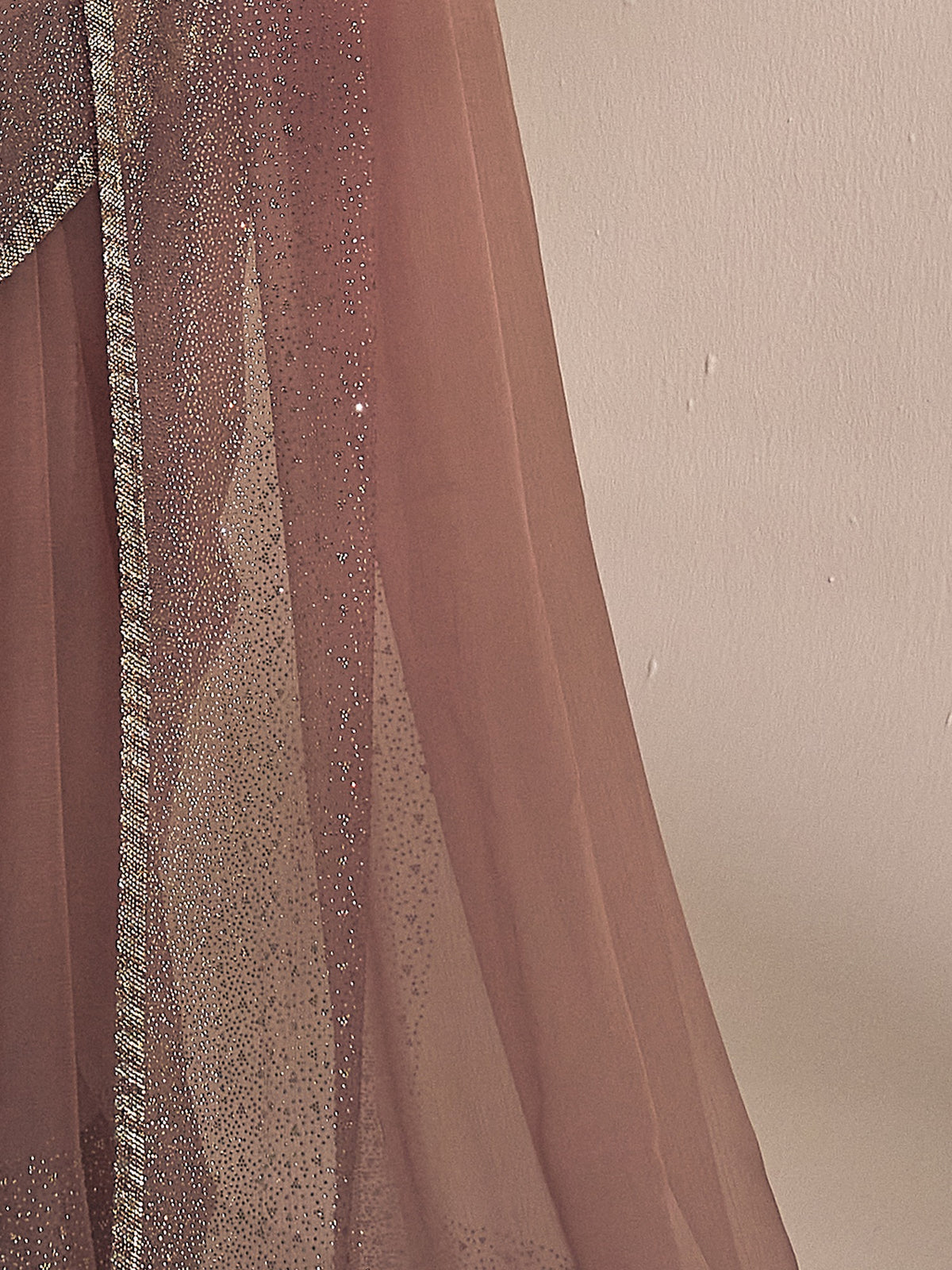 Pallu detail of rose gold chiffon saree showing ornamented surface design and embellished border