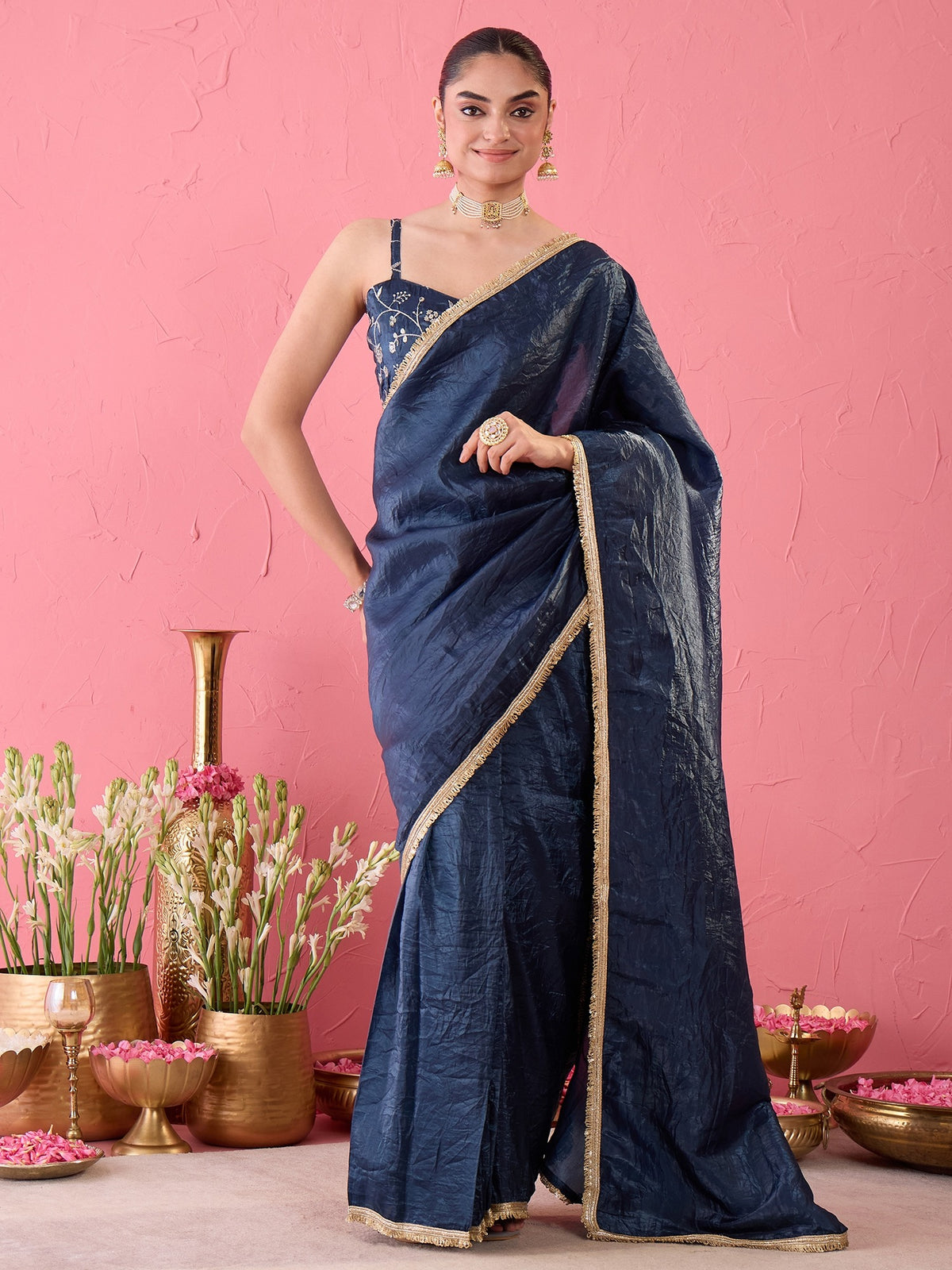 Woman wearing teal blue tissue ready to wear saree with clean solid-tone finish and teal blue blouse