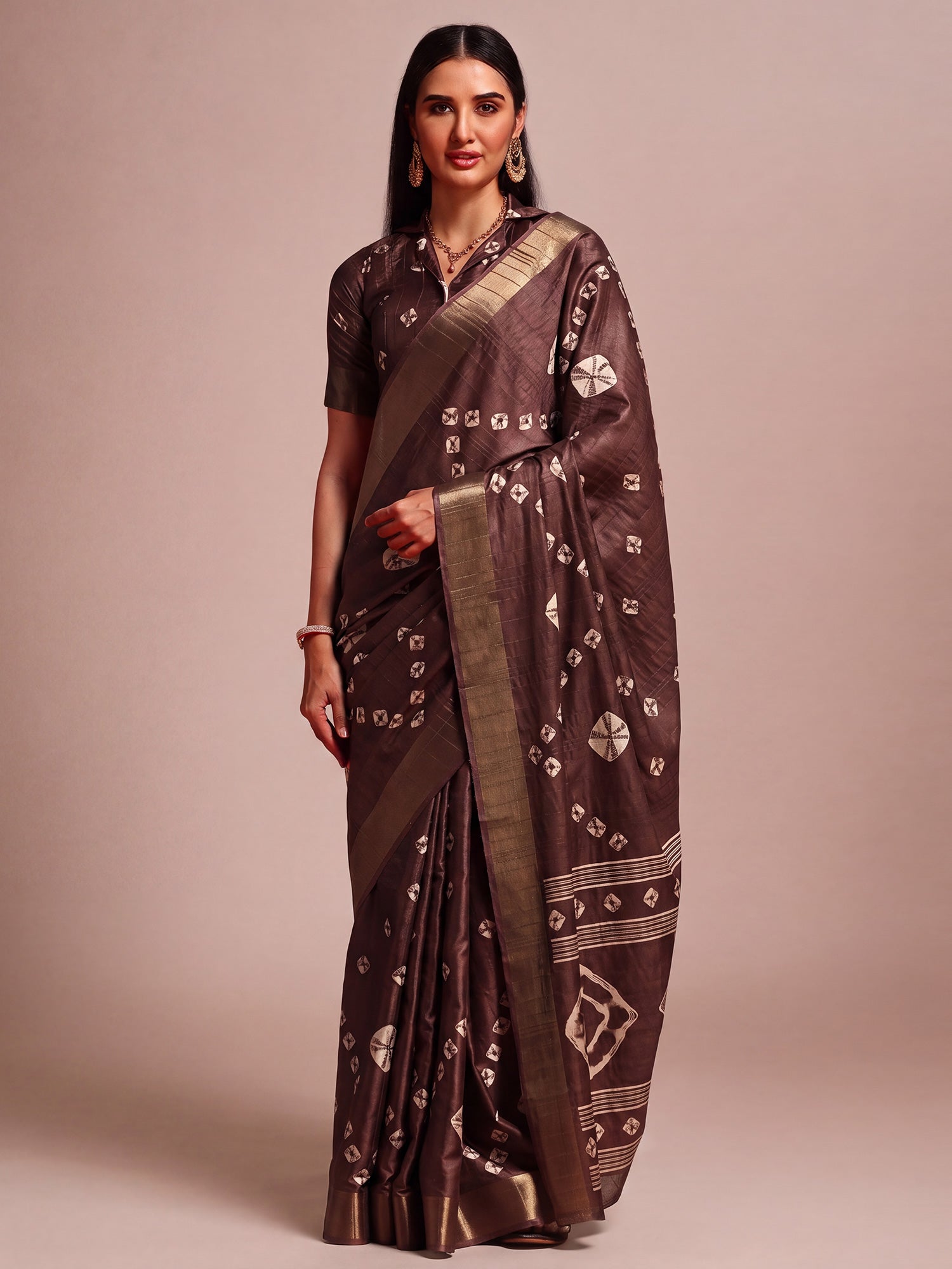 Woman wearing dark brown silk blend saree with traditional indian motif work and dark brown blouse
