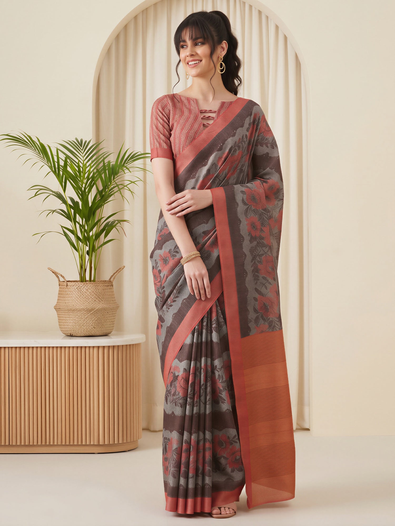 Woman wearing grey cotton blend saree with all-over floral design and rust blouse