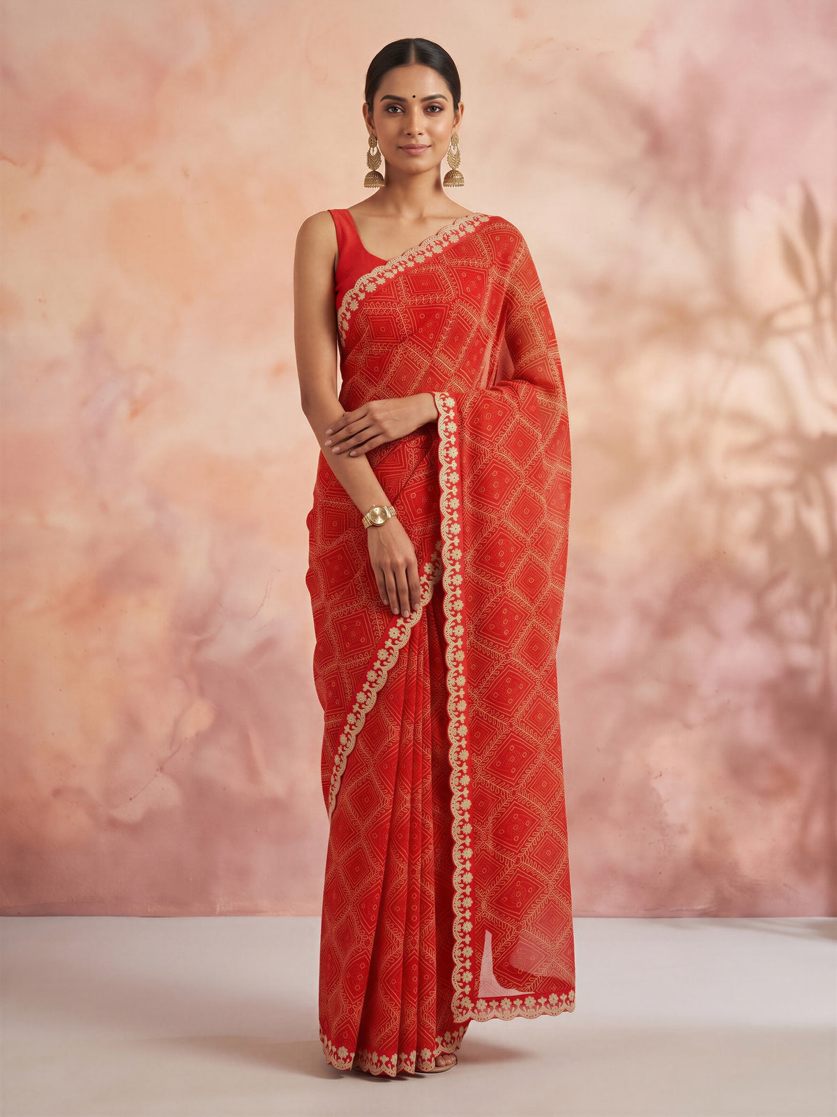 Woman wearing orange georgette saree with bandhani tie-dye dot work and orange blouse
