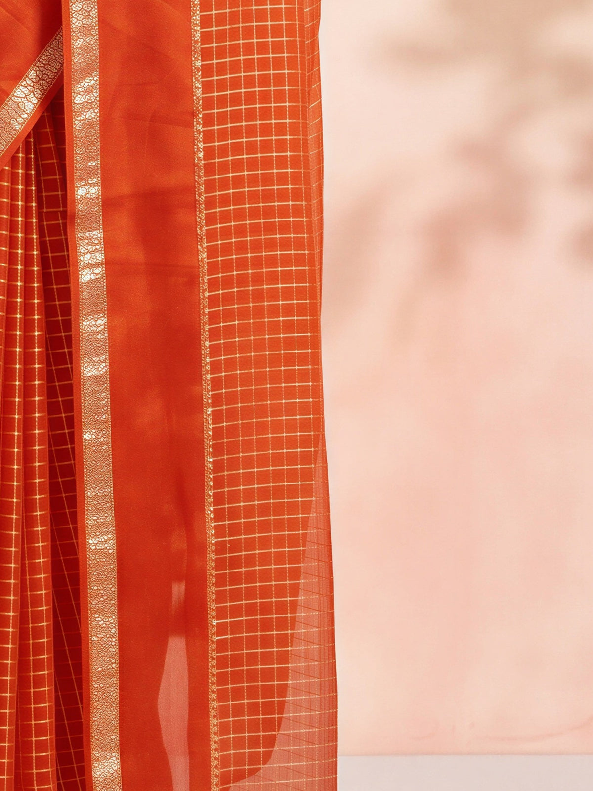 Pallu detail of orange viscose saree showing checked pattern design and zari border