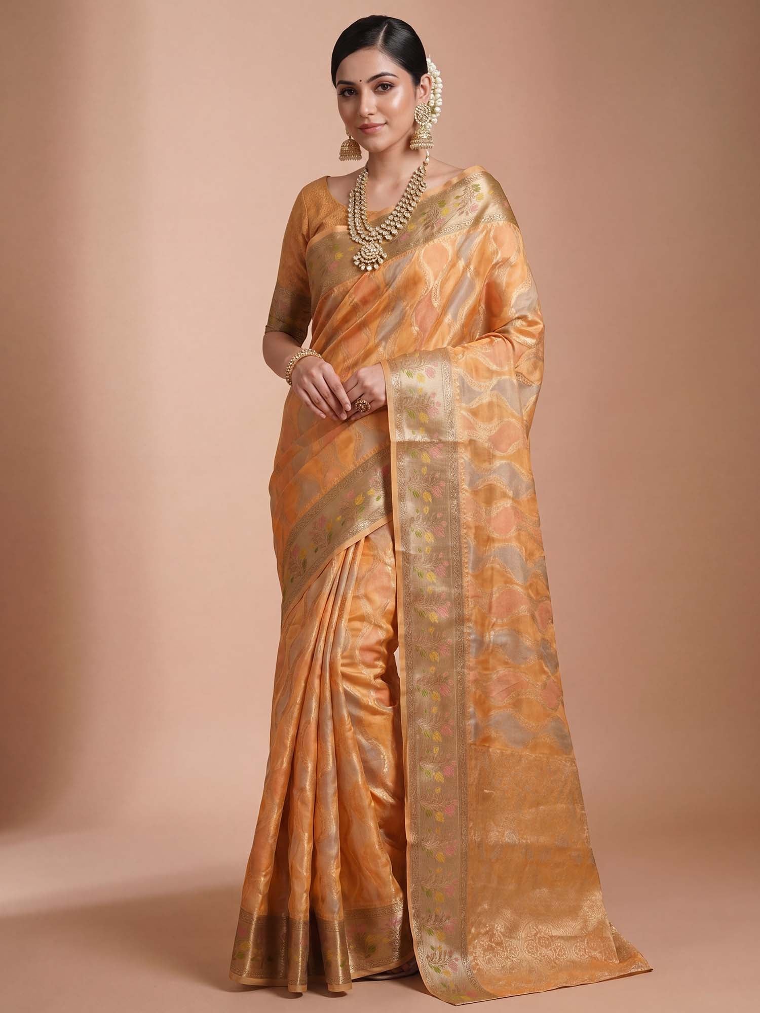 Woman wearing orange organza saree with traditional indian motif work and orange blouse