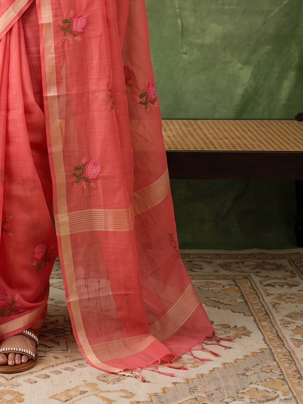 Pallu detail of peach kota doria cotton saree showing embroidered motif work and zari border