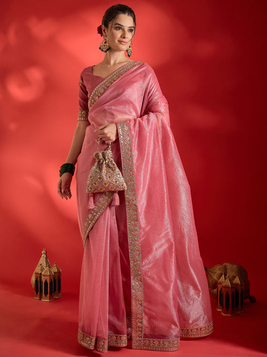 Woman wearing pink net saree with ornamented surface design and pink blouse