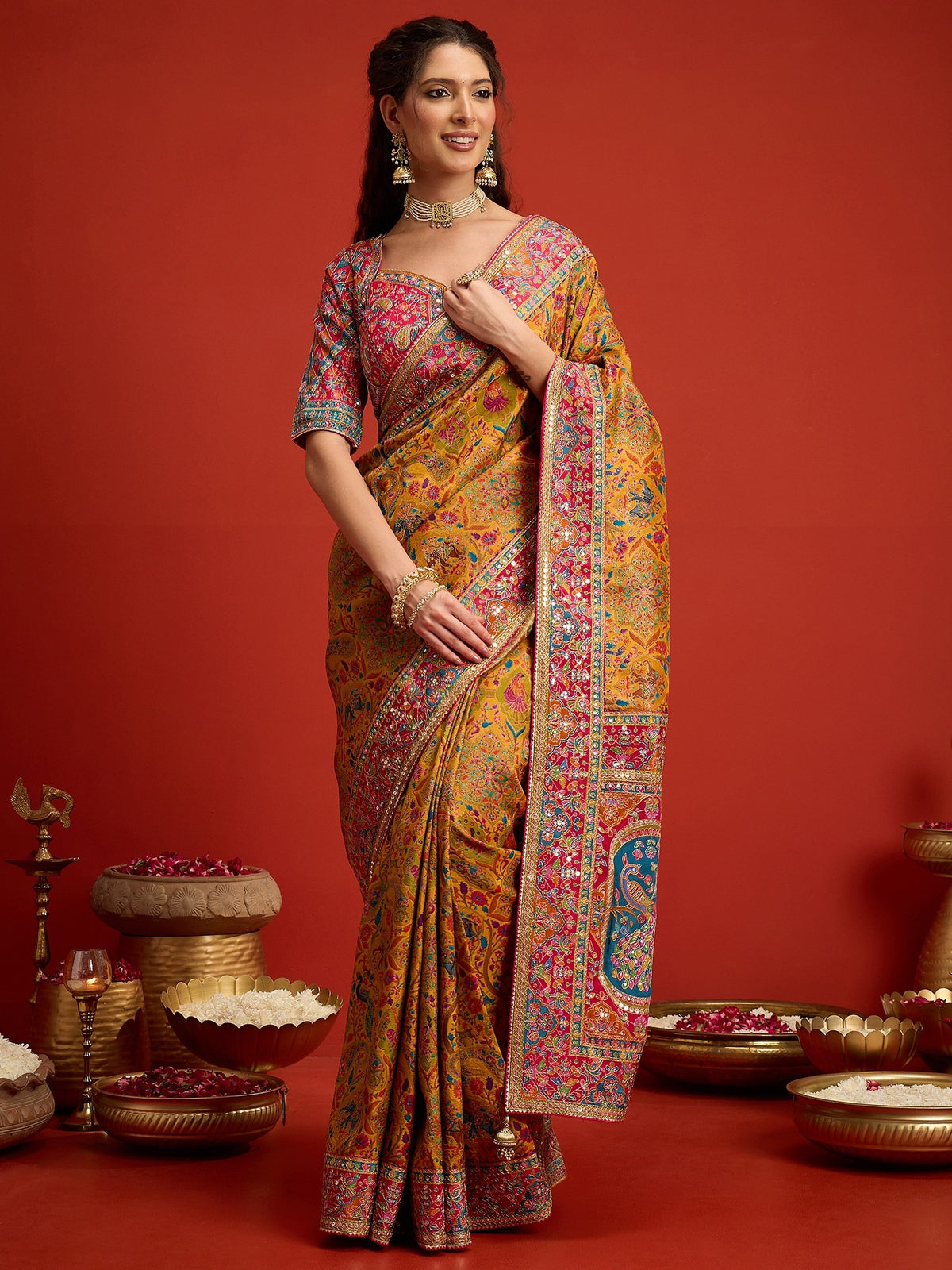 Woman wearing mustard silk blend saree with traditional indian motif work and pink blouse