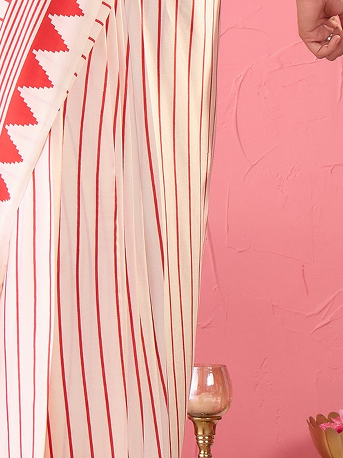 Pallu detail of cream satin saree showing striped pattern design and printed border