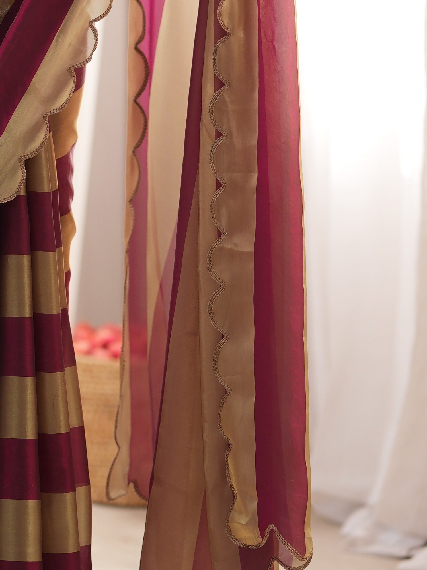 Pallu detail of wine satin saree showing striped pattern design and embroidered border
