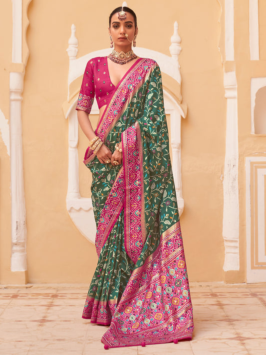 Woman wearing green silk blend saree with ikat resist-dyed pattern and pink blouse