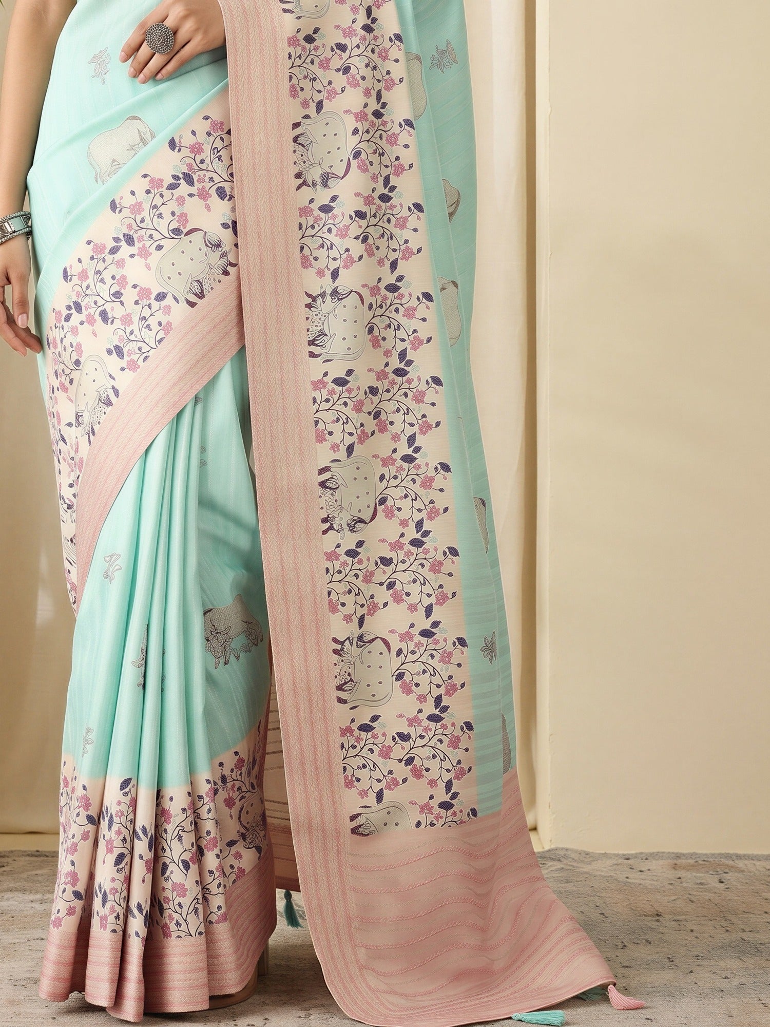 Pallu detail of turquoise silk blend saree showing traditional indian motif work and embroidered border