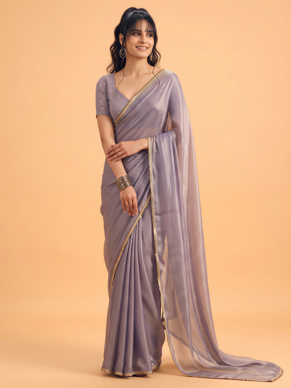 Woman wearing metallic silk saree with clean solid-tone finish and metallic blouse
