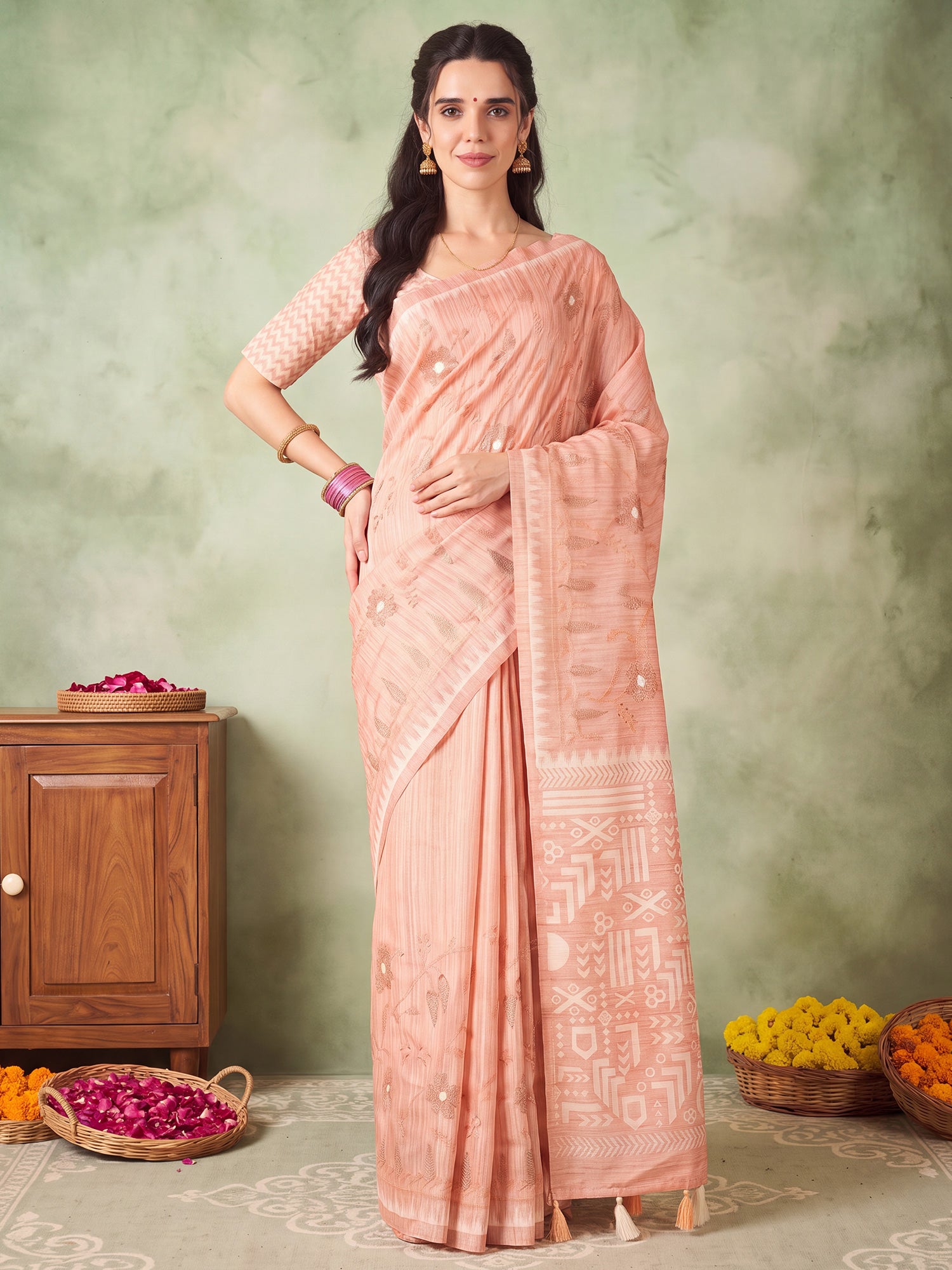 Woman wearing peach silk blend saree with embroidered motif work and peach blouse