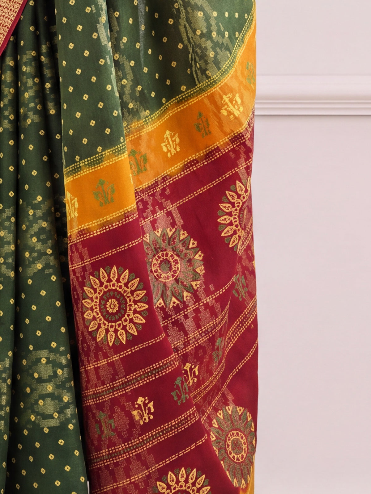 Pallu detail of green cotton saree showing bandhani tie-dye dot work and zari border