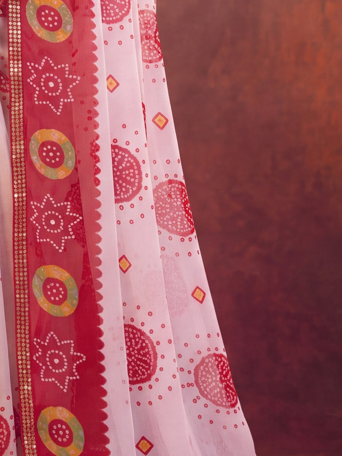 Pallu detail of white georgette saree showing bandhani tie-dye dot work and zari border