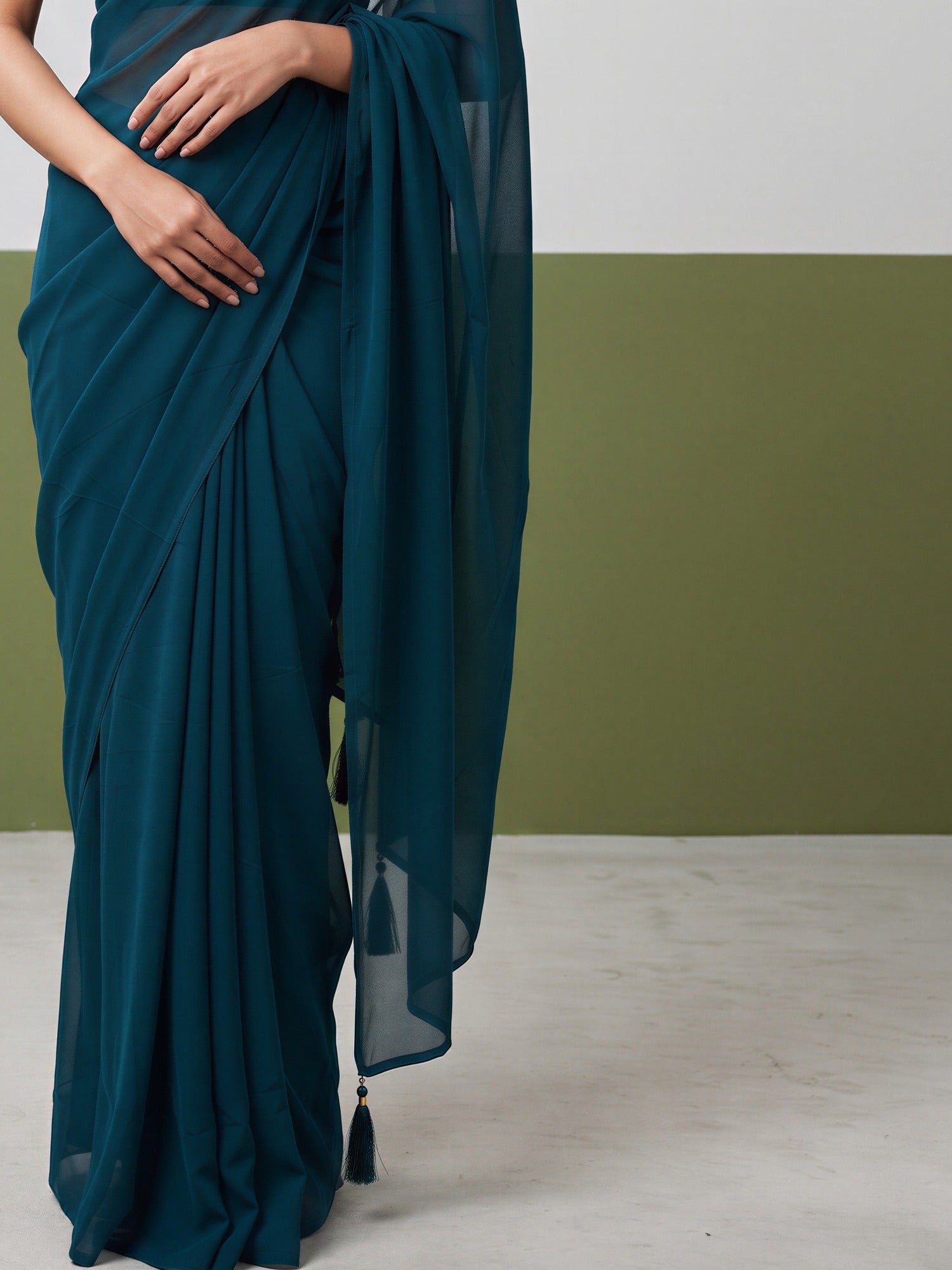 Pallu detail of teal green georgette saree showing clean solid-tone finish and solid border