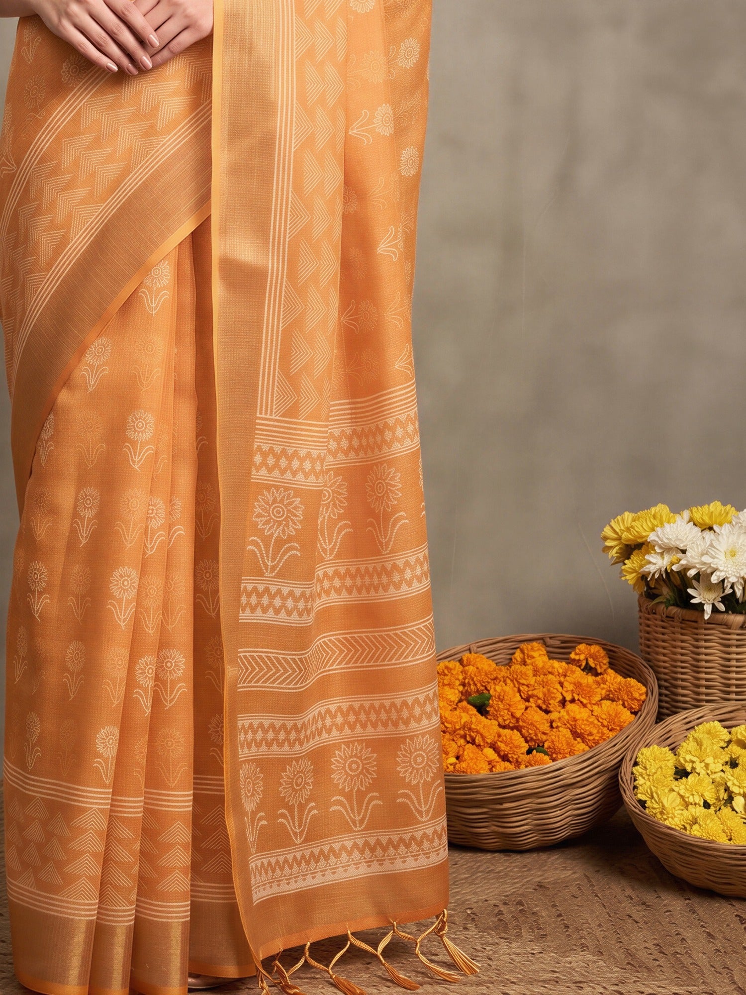 Pallu detail of orange linen saree showing bagh block-print motif work and zari border