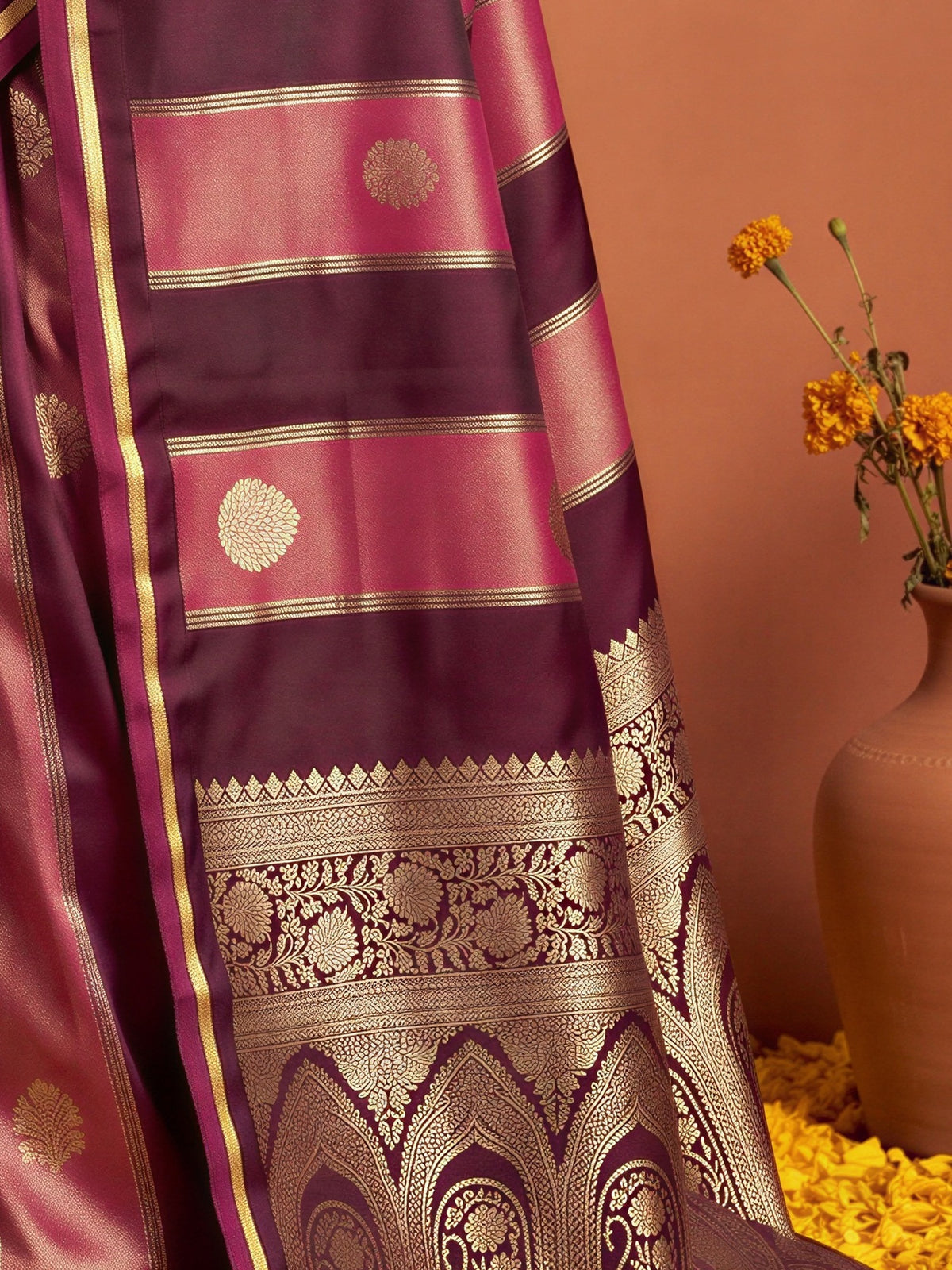 Pallu detail of wine satin saree showing traditional indian motif work and zari border