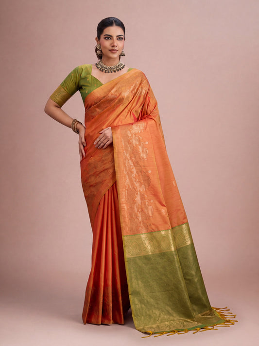 Woman wearing orange tussar silk saree with traditional indian motif work and green blouse