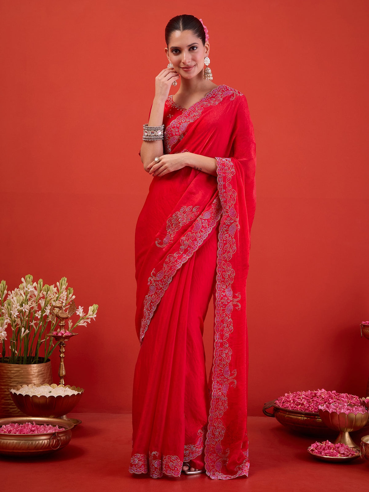 Woman wearing pink satin saree with ornamented surface design and pink blouse