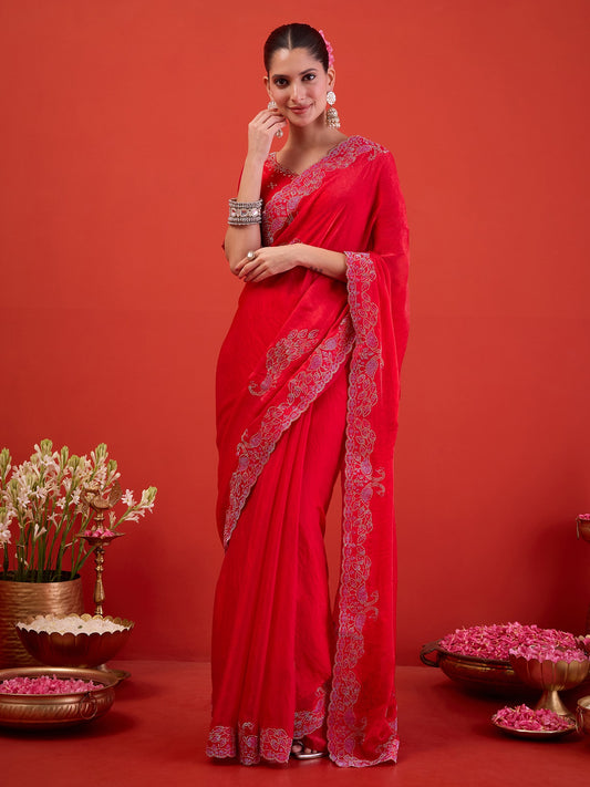 Woman wearing pink satin saree with ornamented surface design and pink blouse