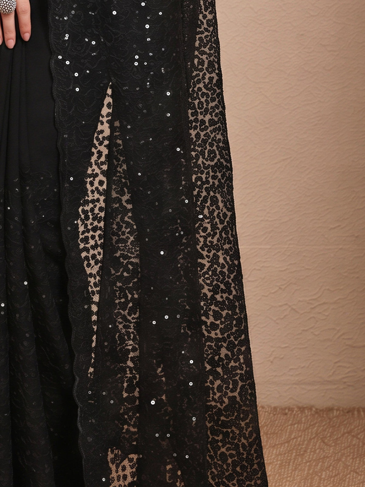 Pallu detail of purple net saree showing embroidered motif work and embellished border